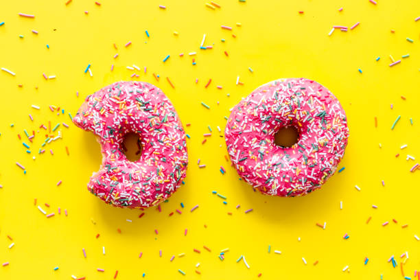 istock Pink berry donuts flat lay, top view. Glazed and sprinkles doughnuts 1266752863