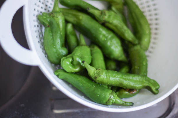 istock Fresh green peppers in a colander. 1266754582