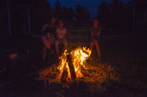 Mother and child in front of campfire at night during summer vacations