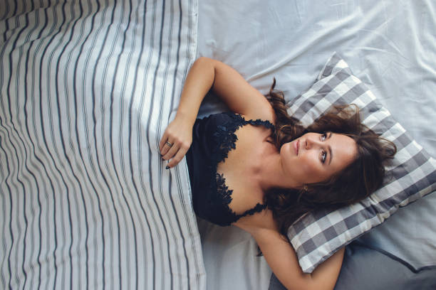 istock High Angle View Of Young Woman Sleeping In Bed With Blanket 1266755783