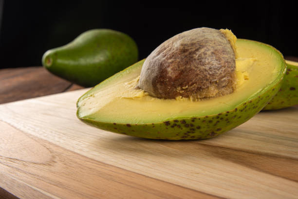 istock Avocados on a polished cutting board on a rustic wooden surface with selective focus. 1266755787