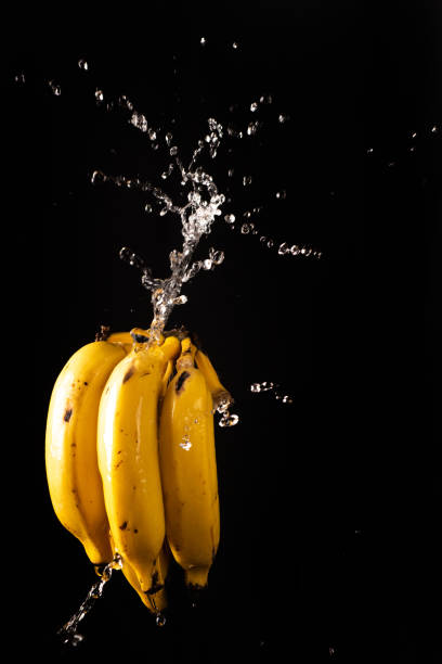 istock Bananas with a beautiful splash of water with black background and selective focus. 1266756520