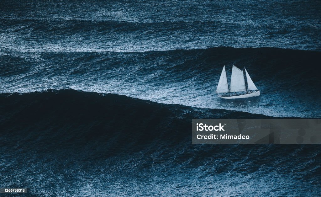 sailboat on the sea with storm and big waves Storm Stock Photo