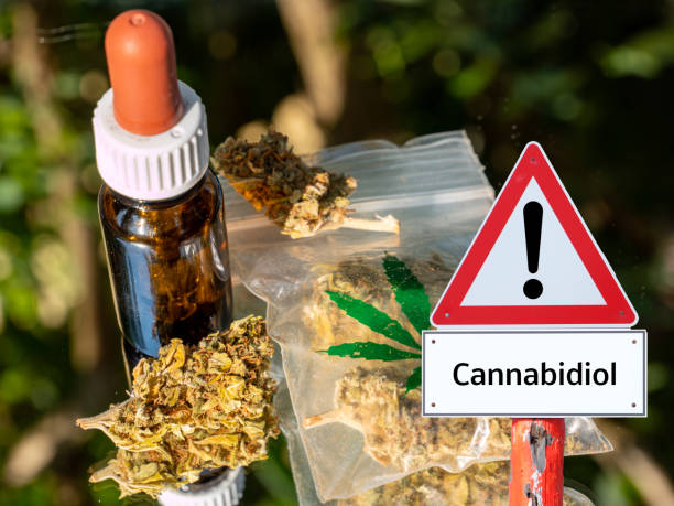 istock bottle with CBD oil and bag with gras warning sign 1266758657