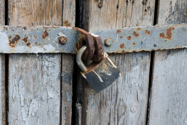 istock Metal padlock on the gate. Closed door. An old rusty padlock. 1266760415