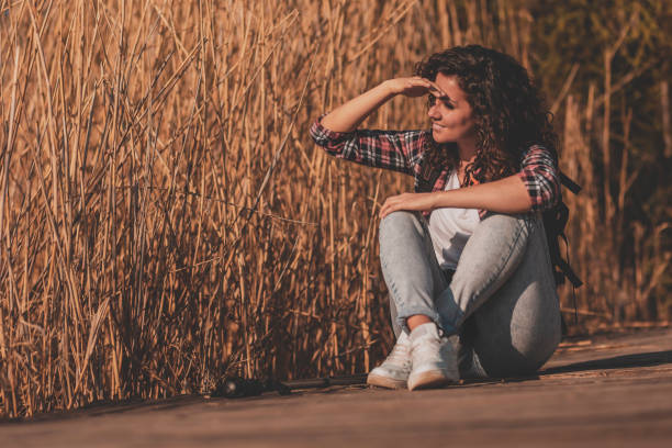 istock Female hiker sitting at lake docks 1266764905
