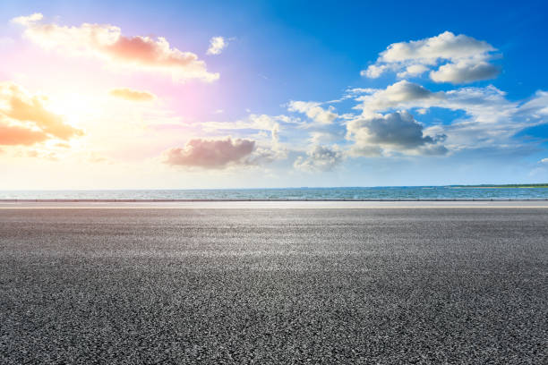 istock Asphalt road and lake scenery at sunset. 1266764911