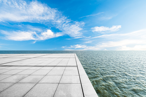 Empty square floor and lake with beautiful clouds.
