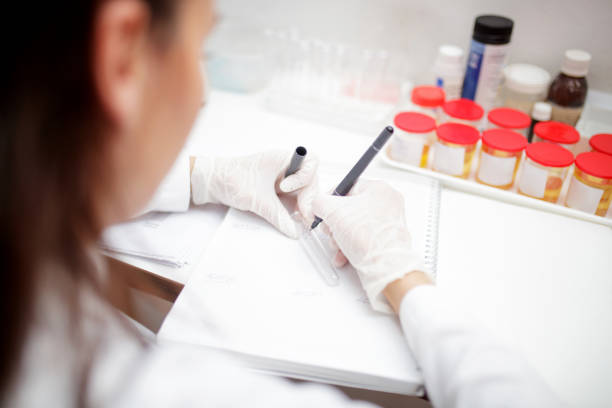 istock Lab technician in protective gloves writing number on empty test tube 1266765440