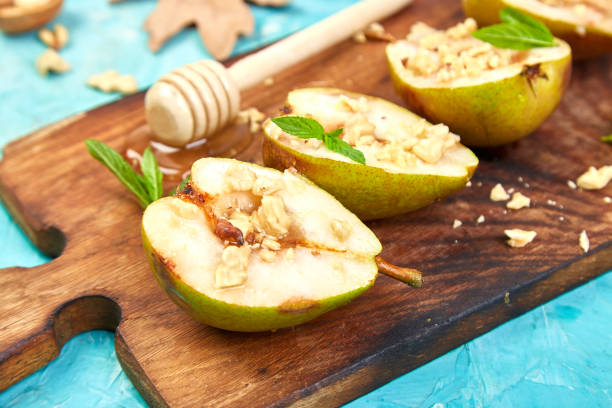 istock Tasty roast pears with honey and walnuts on blue background table. 1266766920