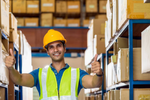 portrait of indian warehouse worker man with safety clothes standing with confident and showing thumps up - thumps up imagens e fotografias de stock