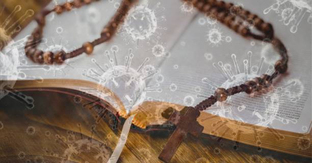 istock Covid-19 cells against rosary on bible 1266769235