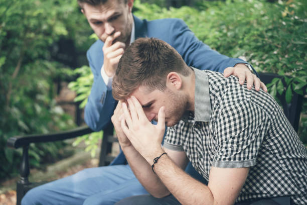 istock Guys Sharing Life Problems Always Support Best Friends. Friends Getting Down Heart Broken. Sad Man sitting outdoor in the park feeling sadness has a problems Life Crisis. Best Friend Mental Concept. 1266773348