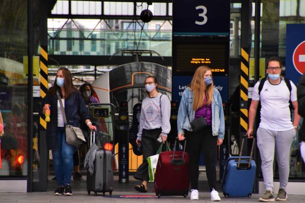 People with protective face masks at King's Cross Station, London London, United Kingdom - August 17 2020: Passengers with protective face masks and luggage leaving King's Cross Station central london photos stock pictures, royalty-free photos & images