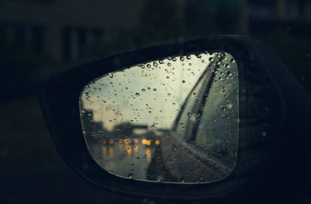 istock Rear view mirror seen through rain drops on the car window. 1266773626