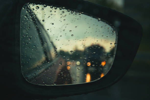 istock Rear view mirror seen through rain drops on the car window. 1266773629