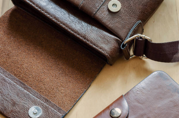 istock Small leather bag and wallet on wooden table. 1266775819