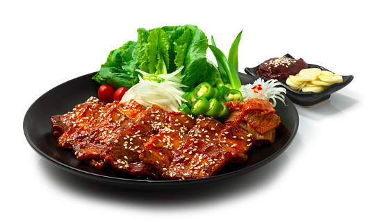 Spicy Grilled Pork Belly with Kochujang Sauce (Dwaeji Bulgogi) is popular Spicy Korean BBQ dish served chili,Kimchi,garlic,kochujang sauce,onion and vegetable sideview