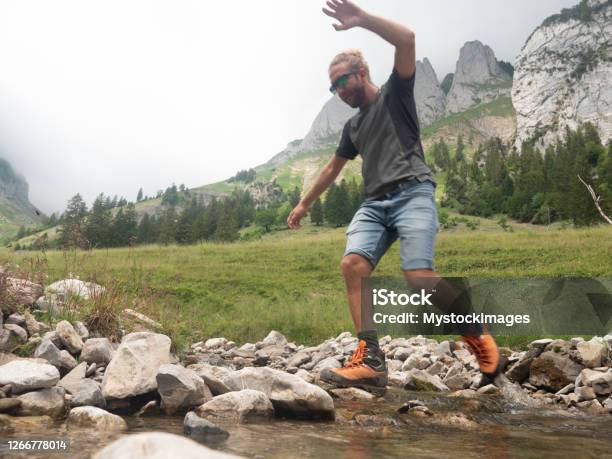 Hiker Jumping Over River Stock Photo - Download Image Now - Jumping, Above, Men