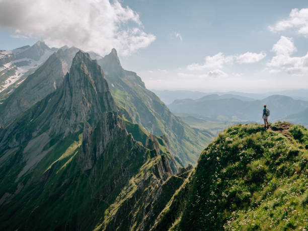 istock Distant view of woman on mountain peak 1266778198