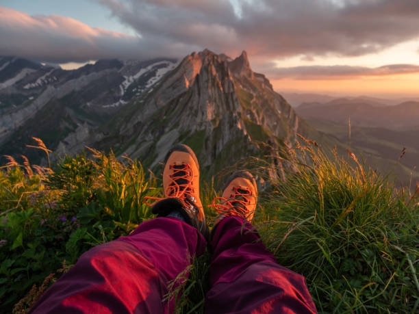 punto de vista de la mujer sentada en la cima de la montaña mirando a la vista - switzerland hiking boot outdoor pursuit recreational pursuit fotografías e imágenes de stock