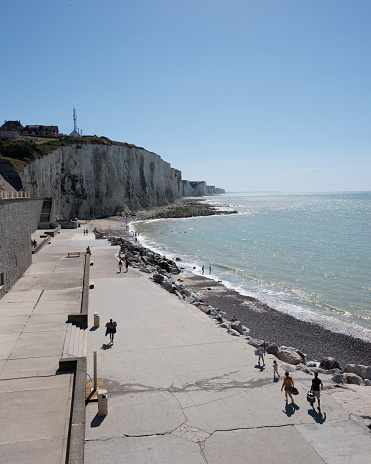 Ault, France, 5 august 2020: people on boulevard and beach of ault in french normandy under blue sky
