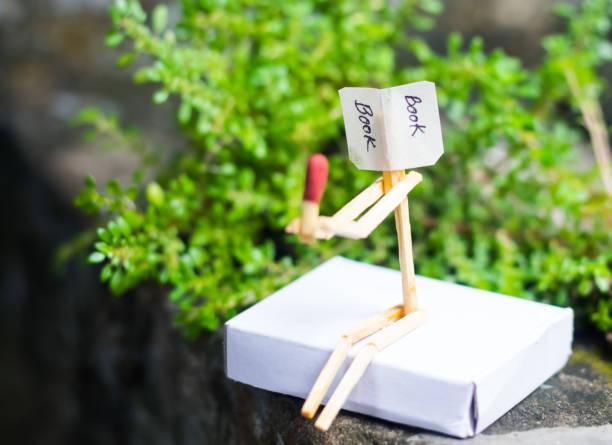 istock Matchstick concept and ideas. Book reading concept and ideas. Matchstick reading a book with green background. 1266780013