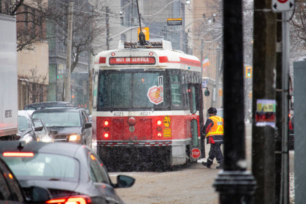 un travailleur de service de la ttc monter à bord d’un véhicule léger sur rail canadien clrv par un après-midi d’hiver enneigé. - ttc photos et images de collection