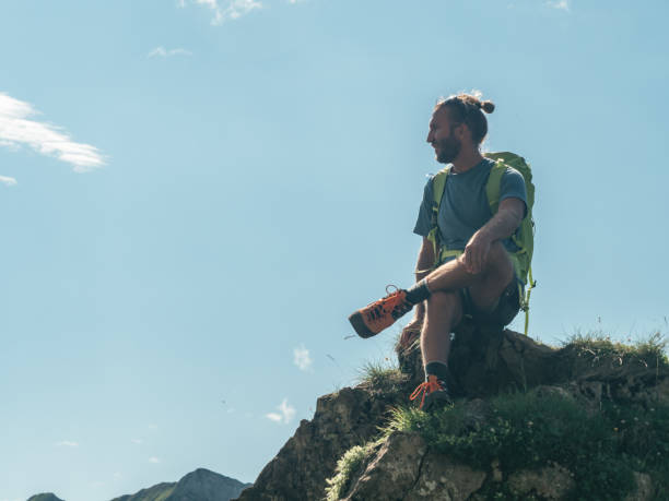 istock Man on mountain peak looking at view from top 1266780383
