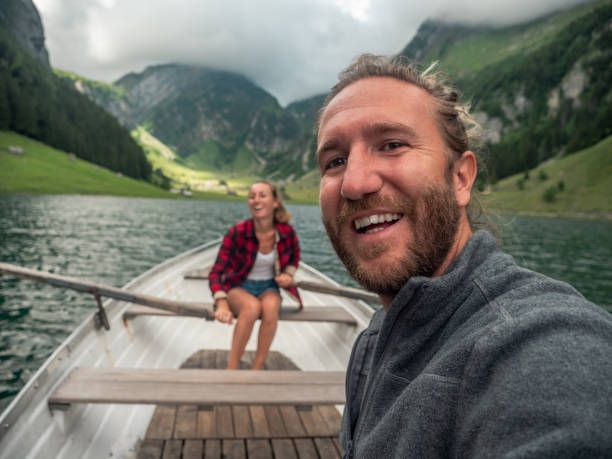 istock Couple takes selfie while relaxing on rowing boat, alpine lake 1266780431