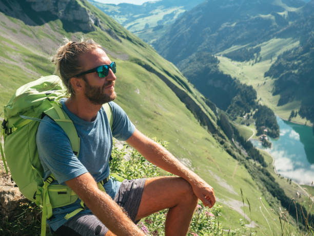istock Man on mountain peak looking at view from top 1266780448