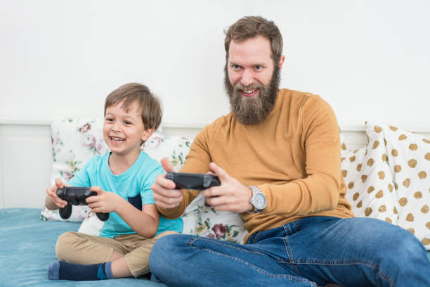 istock Boy playing video games with his dad 1266780832