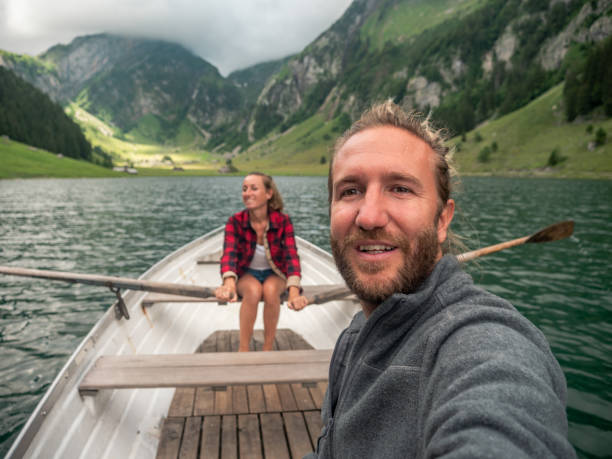 istock Couple takes selfie while relaxing on rowing boat, alpine lake 1266781102