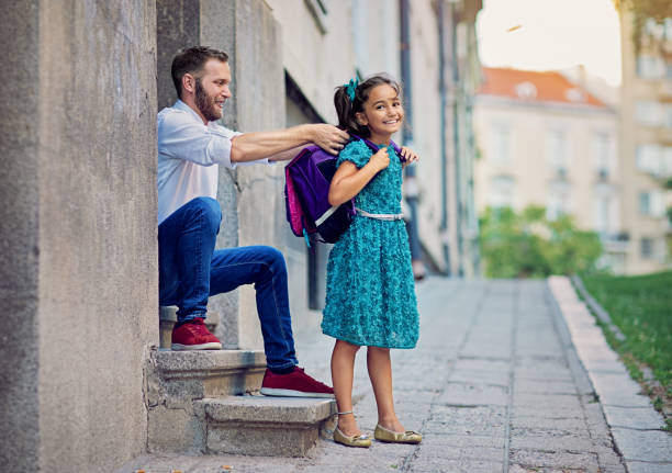 istock Father is sending his happy daughter to school 1266781234
