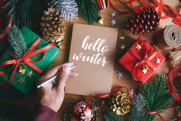 istock Hello winter with human hand writing greeting cards with gift box present and ornament 1266781885