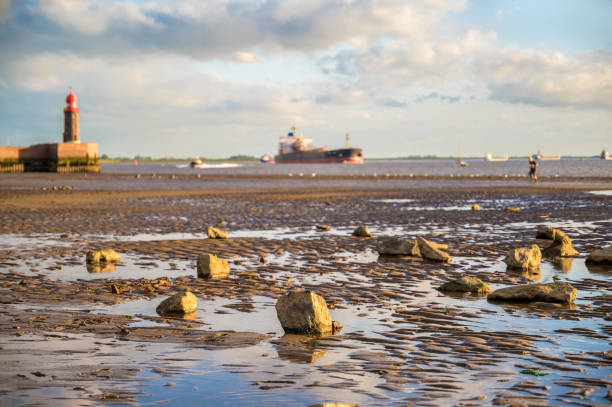 playa en bremerhaven en marea baja con envío en el weser en el fondo - lighthouse beacon north sea coastal feature fotografías e imágenes de stock