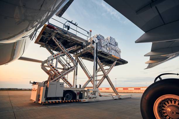 Loading of cargo containers to airplane Preparation before flight. Loading of cargo containers to airplane at airport. flapping stock pictures, royalty-free photos & images