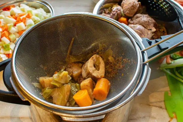 Clarify a Beef broth. colander with bones and cooked vegetables
