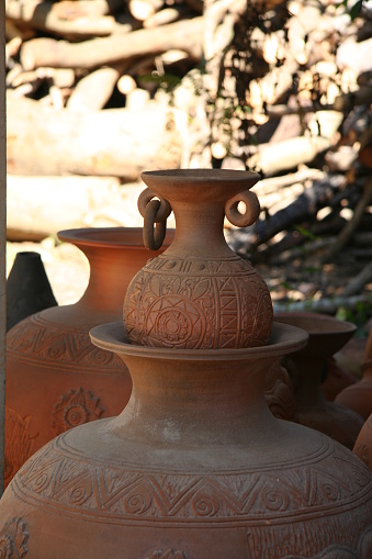 Thai earthenware handmade carved pots arranged in a pattern of Thai art