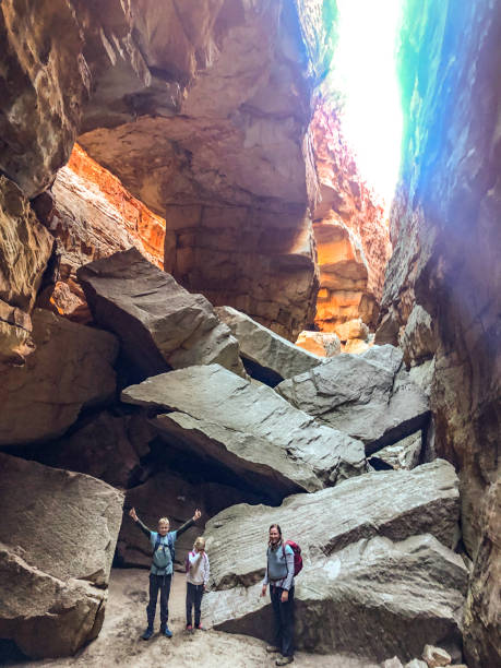 istock Mother with two kids under a sandstone rock arch cave 1266787632