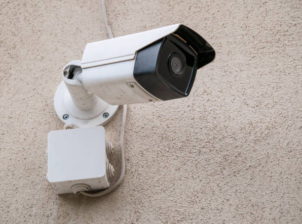 istock Close up with a white security surveillance camera. CCTV camera on a wall. 1266792973