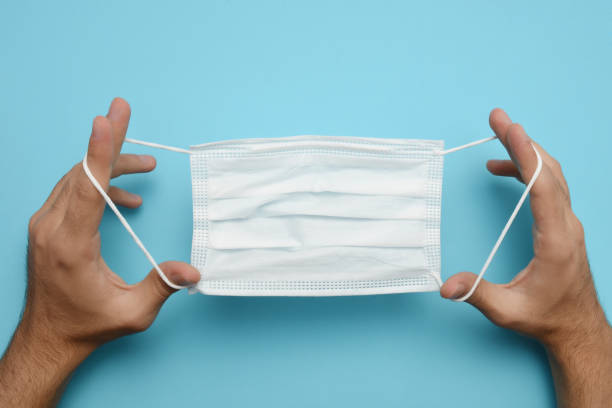 istock Man hands holding protective face mask, medical mask 1266794987