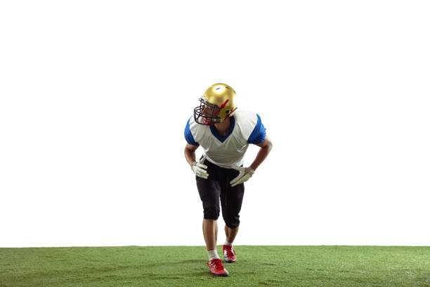 Rear view close up of a Caucasian male American football player wearing a team uniform, pads and a helmet on black background