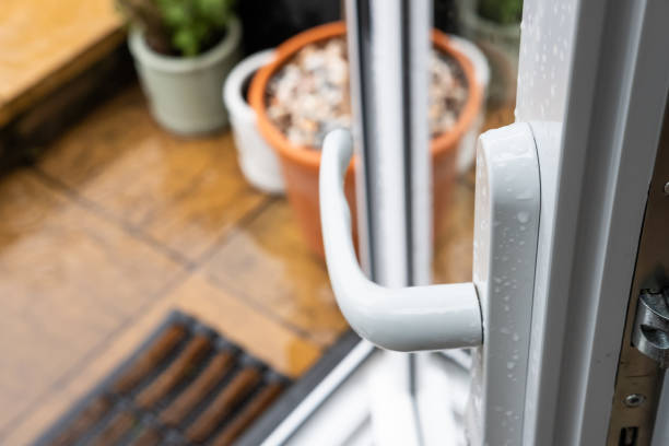 Shallow focus of a newly installed uPVC patio door. Shallow focus of a newly installed uPVC patio door, seen opened leading to a wet patio area at the back of a house. key doormat stock pictures, royalty-free photos & images