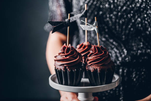 istock Woman holding chocolate cupcakes 1266799464