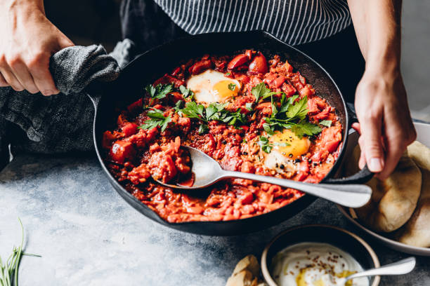 istock Woman preparing shakshuka with poached eggs 1266800901