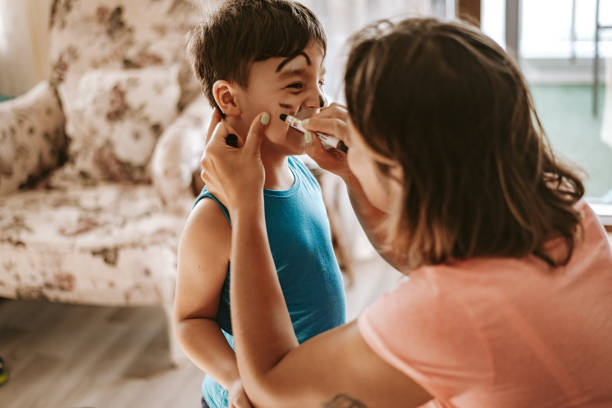 istock Mommy is doing face painting for her son 1266801425