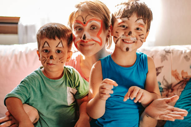 Mom and children spending fun time at home during quarantine days Mom and children spending fun time at home during quarantine days cat face paint stock pictures, royalty-free photos & images