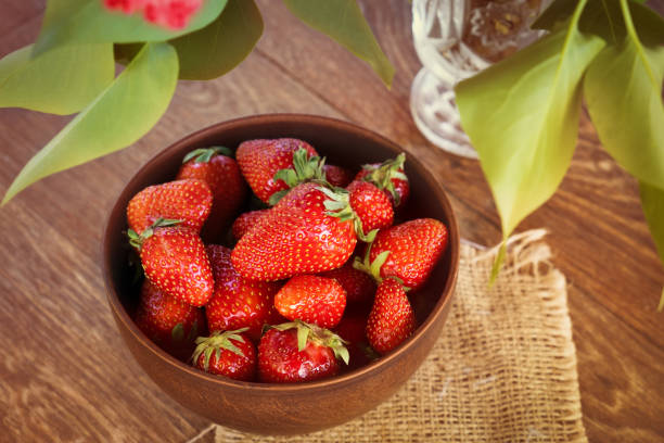 istock Strawberries in a bowl on wooden table 1266803208