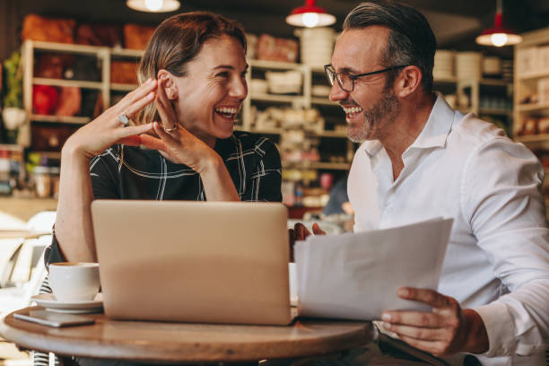 istock Smiling business people working at coffee shop 1266803852